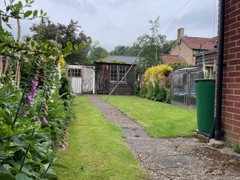 Lot: 20 - THREE-BEDROOM COTTAGE FOR IMPROVEMENT - Rear garden with lawn and two sheds